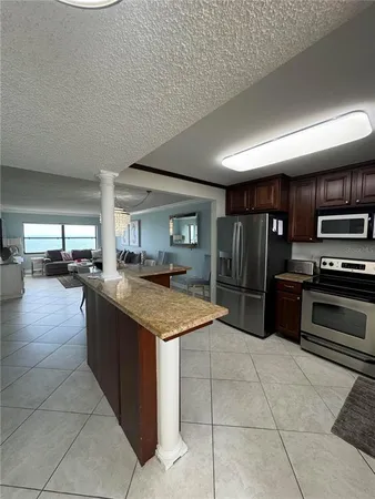 a kitchen with stainless steel appliances granite countertop a table and chairs