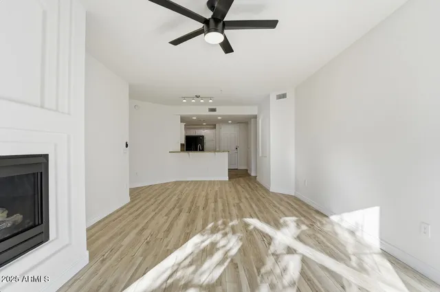a view of empty room with wooden floor and fireplace