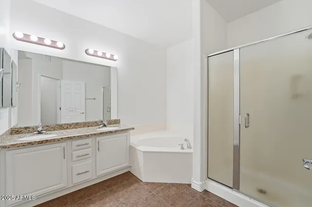 a bathroom with a granite countertop sink a mirror and a bathtub