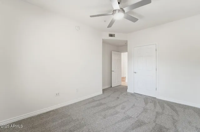 an empty room with a ceiling fan and a fan