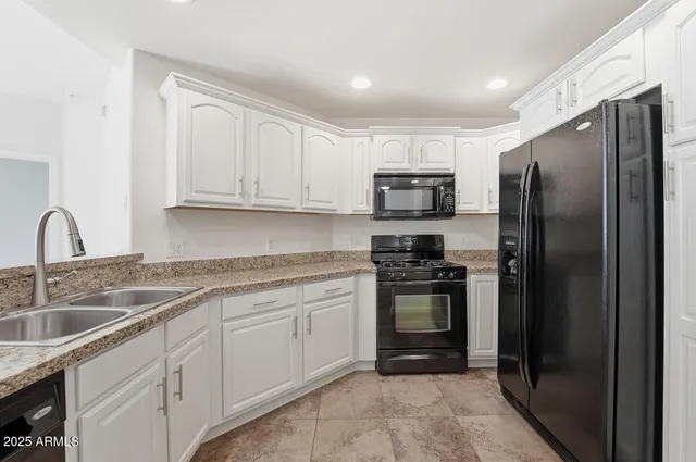 a kitchen with stainless steel appliances granite countertop a refrigerator sink and stove