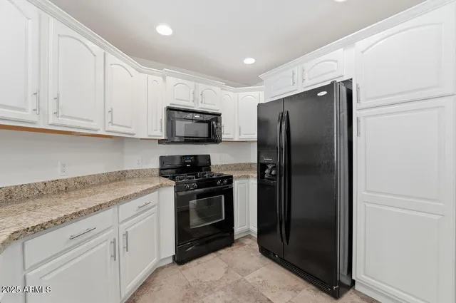 a kitchen with stainless steel appliances granite countertop a refrigerator stove and sink