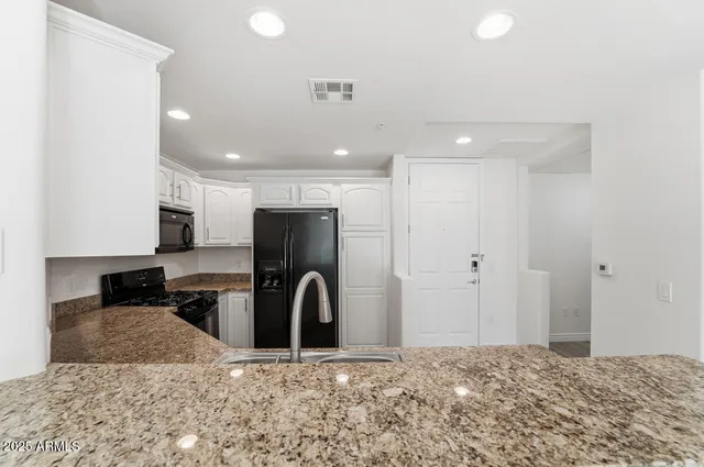 a kitchen with a refrigerator and a stove top oven