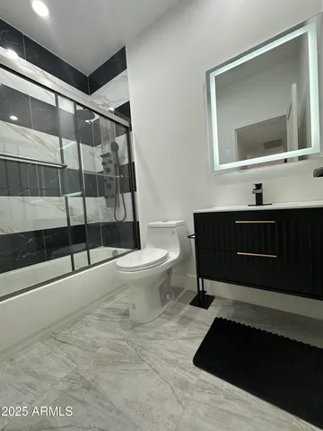 a bathroom with a sink toilet a mirror and shower