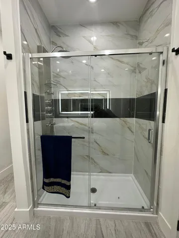 a bathroom with a shower and mirror