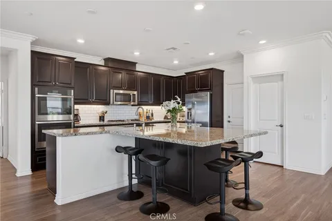 a kitchen with stainless steel appliances granite countertop a sink a stove and refrigerator
