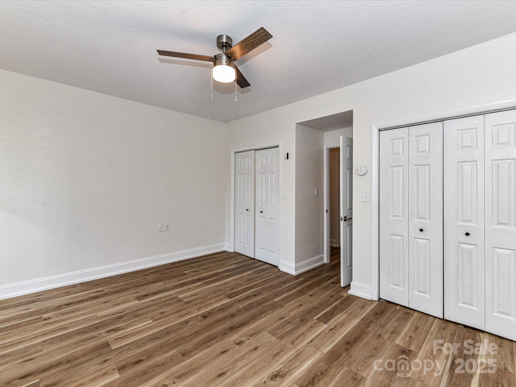 1300 Reece Road, Unit 111 Charlotte, NC 28209 - Photo 16 of 29 an empty room with wooden floor closet and windows