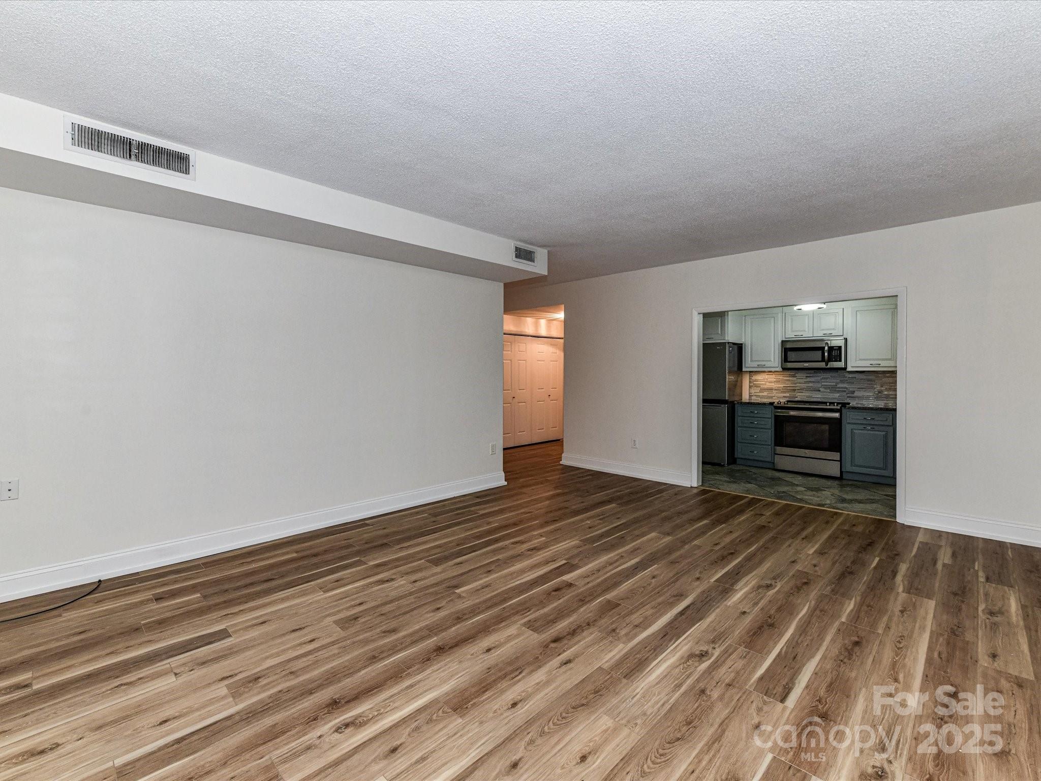 1300 Reece Road, Unit 111 Charlotte, NC 28209 - Photo 2 of 29 a view of empty room with wooden floor