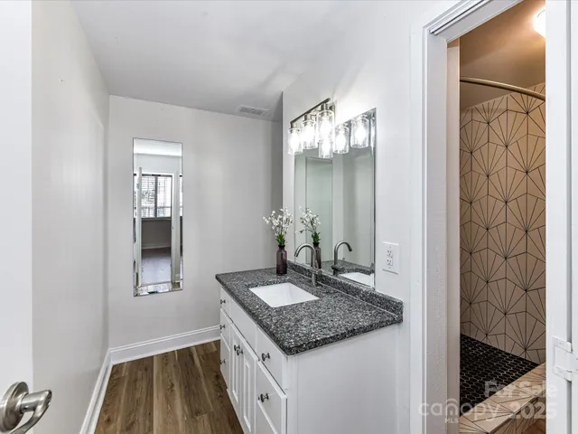 a bathroom with a granite countertop sink and a mirror