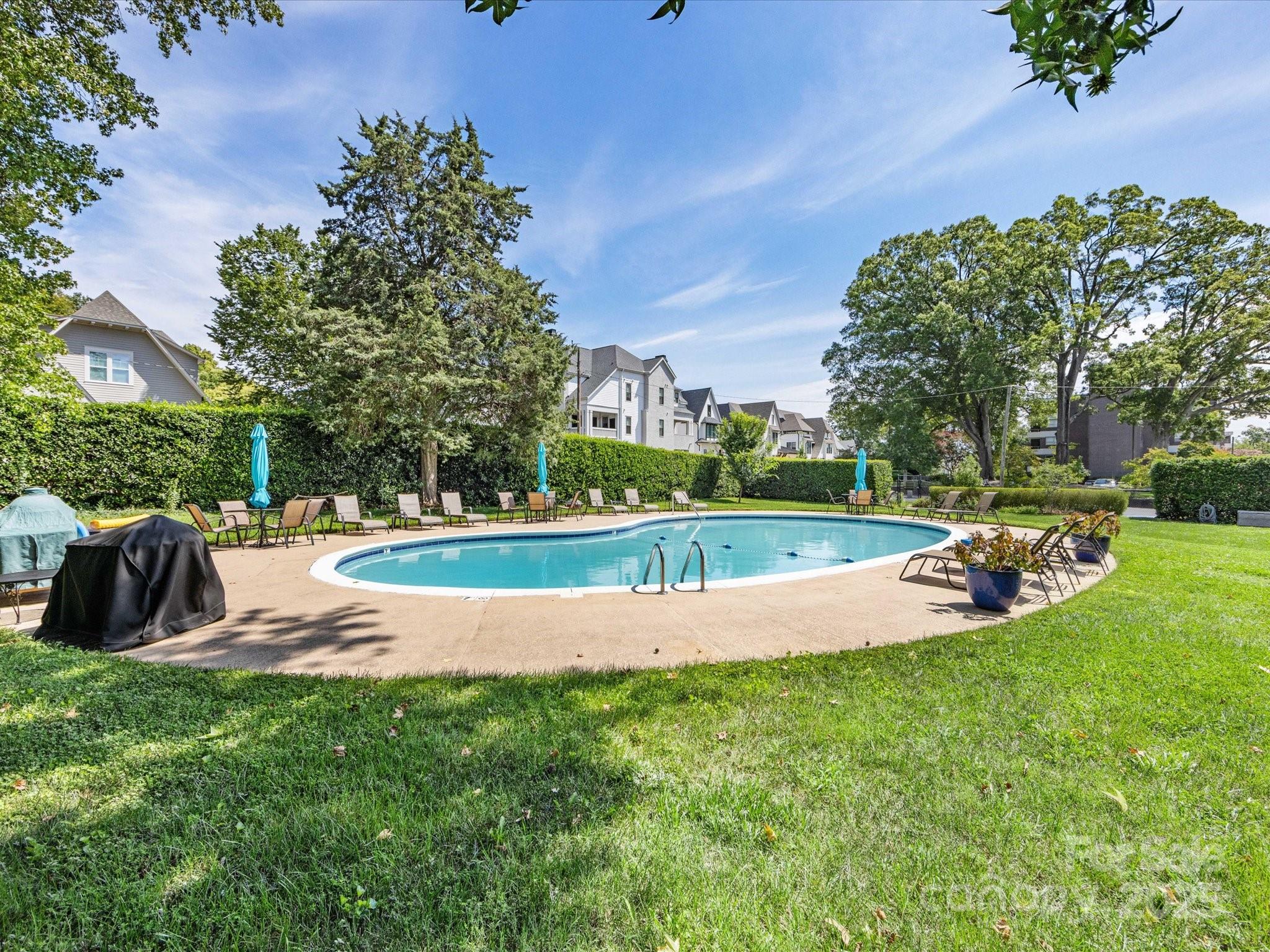 1300 Reece Road, Unit 111 Charlotte, NC 28209 - Photo 27 of 29 a view of a swimming pool and trees in the background