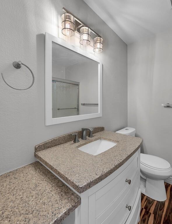 1362 South 12th Street, Unit 22 Waco, TX 76706 - Photo 20 of 31 White vanity with curved drawer fronts, integrated sink, and speckled countertop