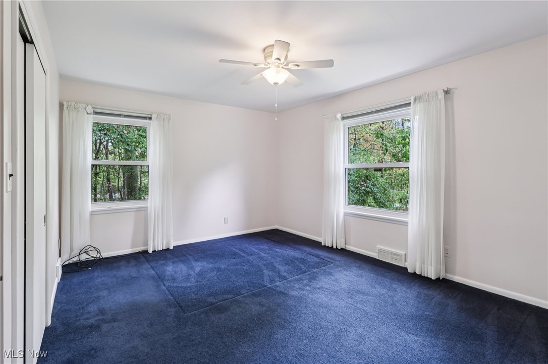 33300 South Woodland Road Cleveland, OH 44124 - Photo 32 of 50 Spare room with dark colored carpet, plenty of natural light, and a ceiling fan