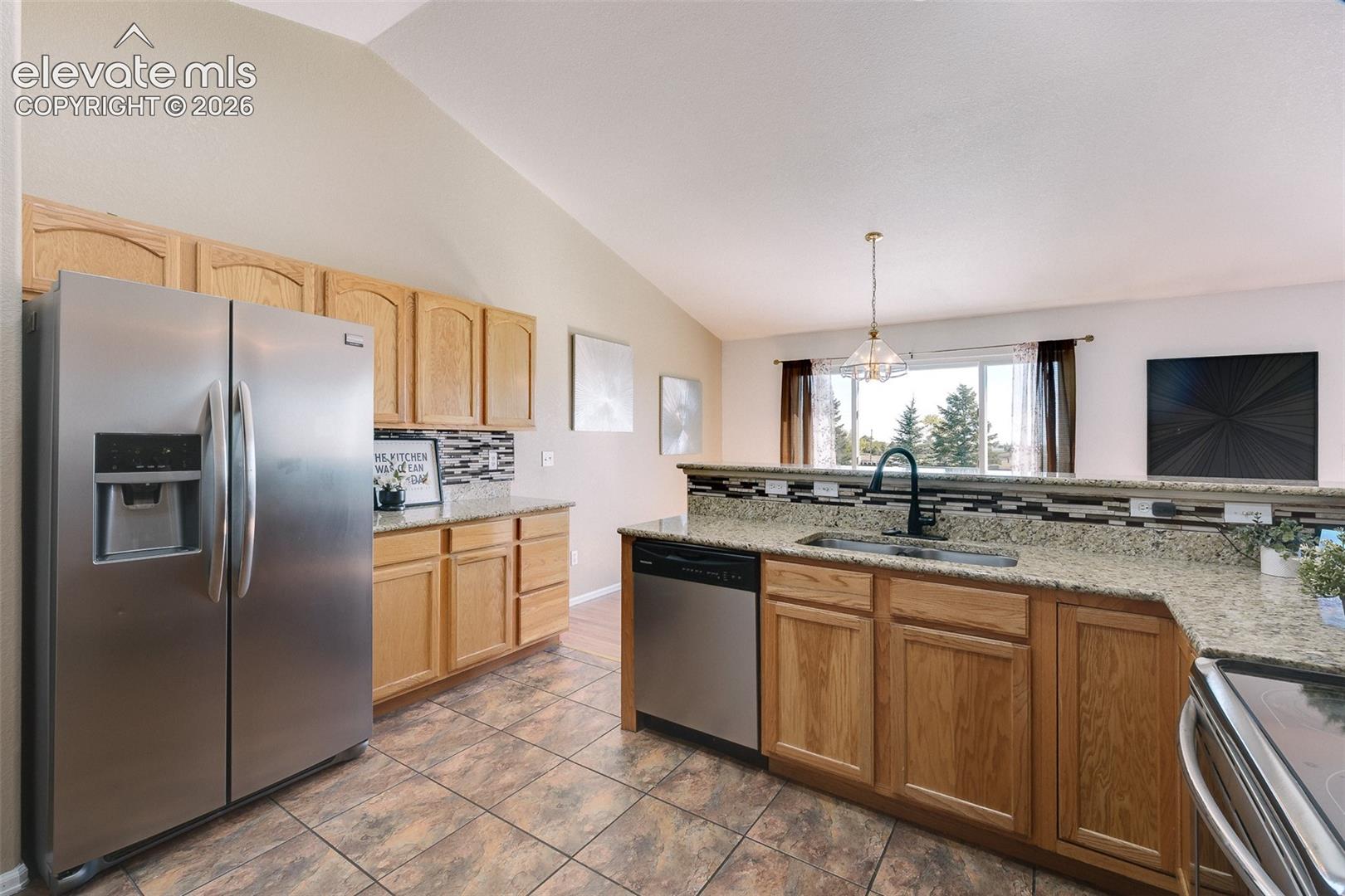 7869 Fort Smith Road Peyton, CO 80831 - Photo 7 of 50 The Kitchen features tile flooring, wood cabinetry with granite countertops and tile backsplash, and stainless steel appliances.