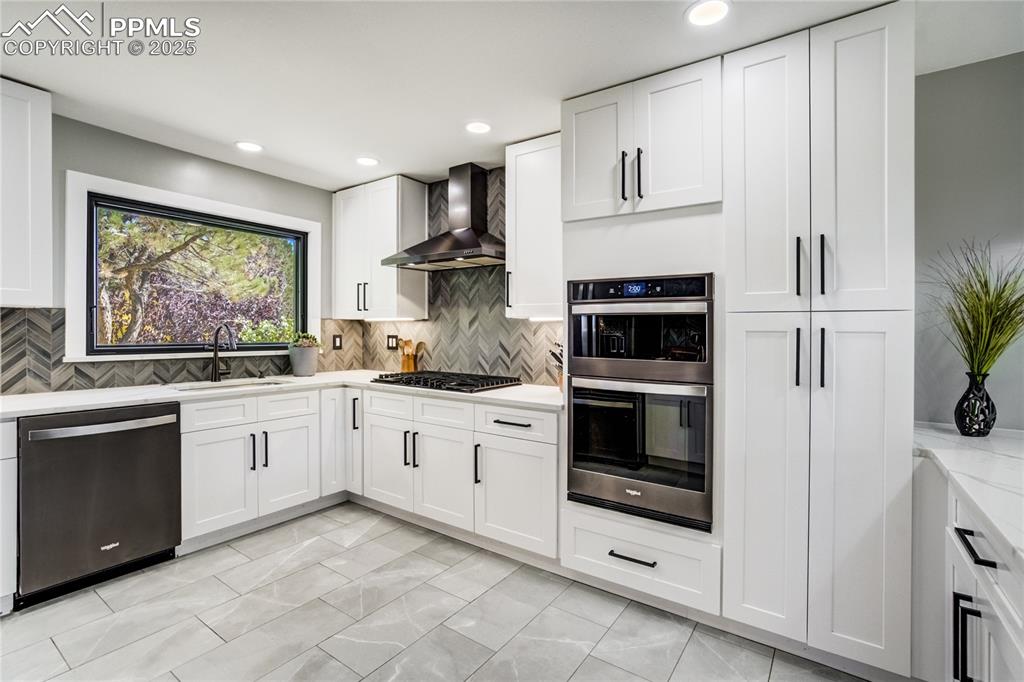 204 Mitchell Avenue Monument, CO 80132 - Photo 15 of 46 a kitchen with granite countertop white cabinets and white appliances