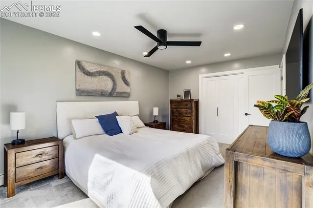 a spacious bedroom with a bed and a potted plant