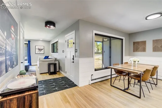 a kitchen with stainless steel appliances granite countertop a stove top oven a sink dishwasher and white cabinets with wooden floor