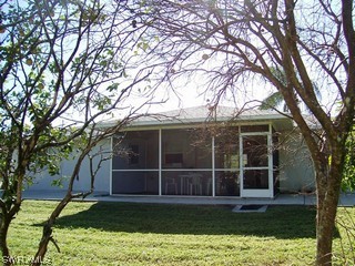 18481 Tulip Road Fort Myers, FL 33967 - Photo 7 of 8 a view of a backyard with floor to ceiling window and a large tree
