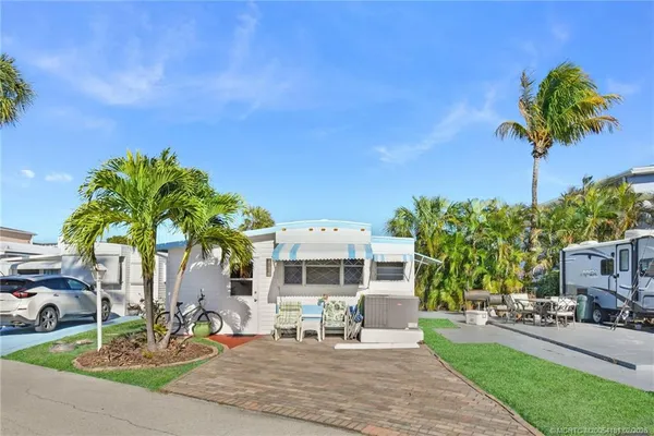 a front view of a house with garden and sitting area
