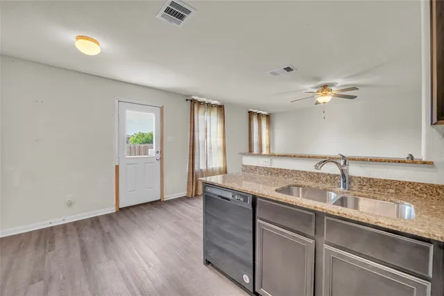 a kitchen with a sink cabinets and wooden floor