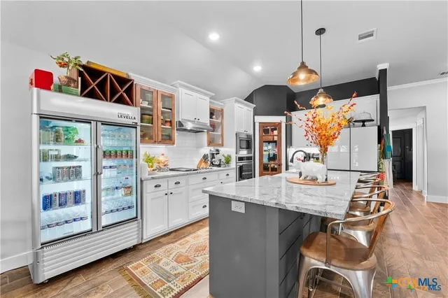 a open kitchen with stainless steel appliances granite countertop a stove and cabinets with wooden floor
