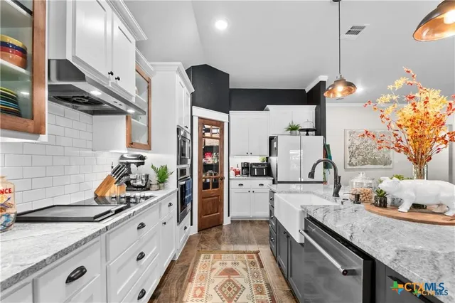a kitchen with stainless steel appliances granite countertop a sink stove and refrigerator