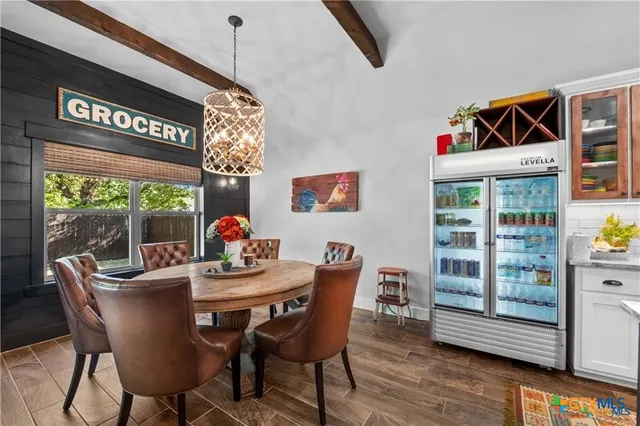 a dining room with furniture a rug a flat screen tv and a large window