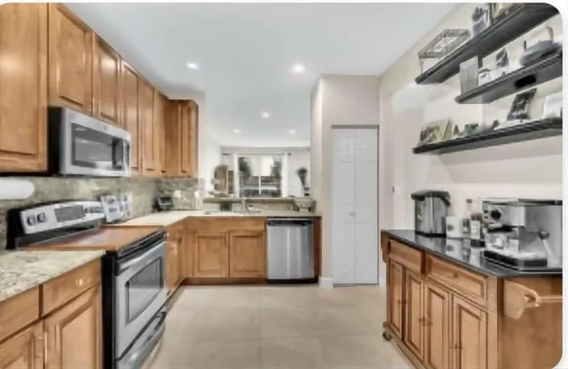 a kitchen with granite countertop stainless steel appliances and cabinets