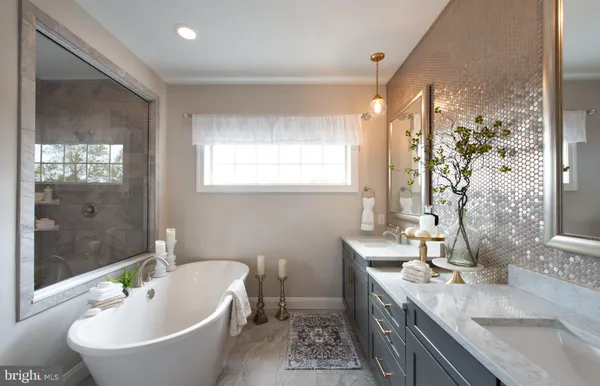 a bathroom with a granite countertop sink a mirror a bathtub and shower