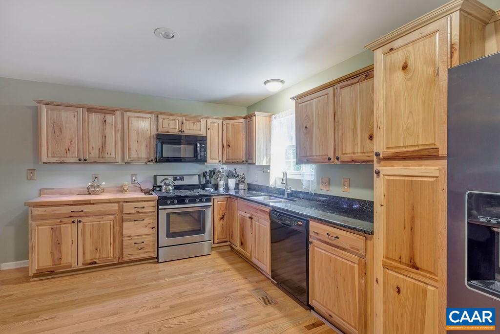 5 Cliftwood Road Palmyra, VA 22963 - Photo 9 of 49 a kitchen with stainless steel appliances granite countertop a stove top oven a sink and dishwasher a refrigerator with wooden floors