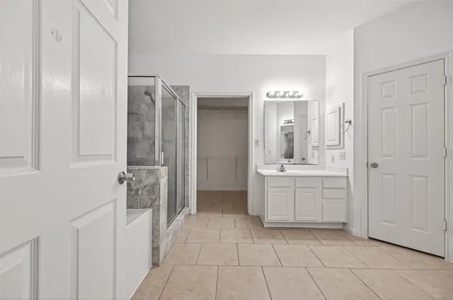 a spacious bedroom with a large bed and a chandelier