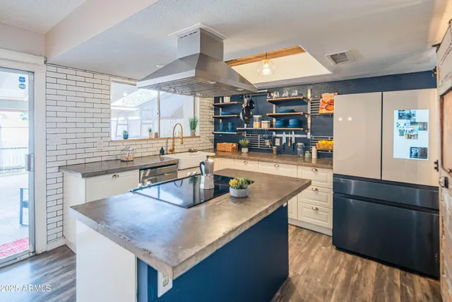 a kitchen with granite countertop a sink a counter top space and living room area