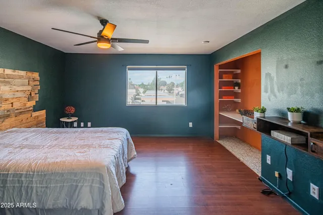 a bedroom with a bed and a chandelier fan