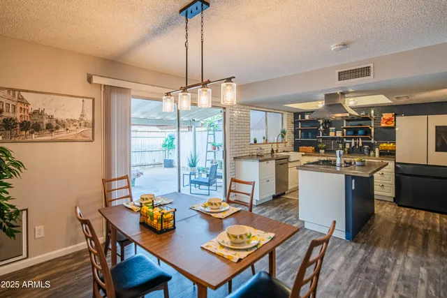 a open dining room with stainless steel appliances kitchen island granite countertop furniture and a wooden floor