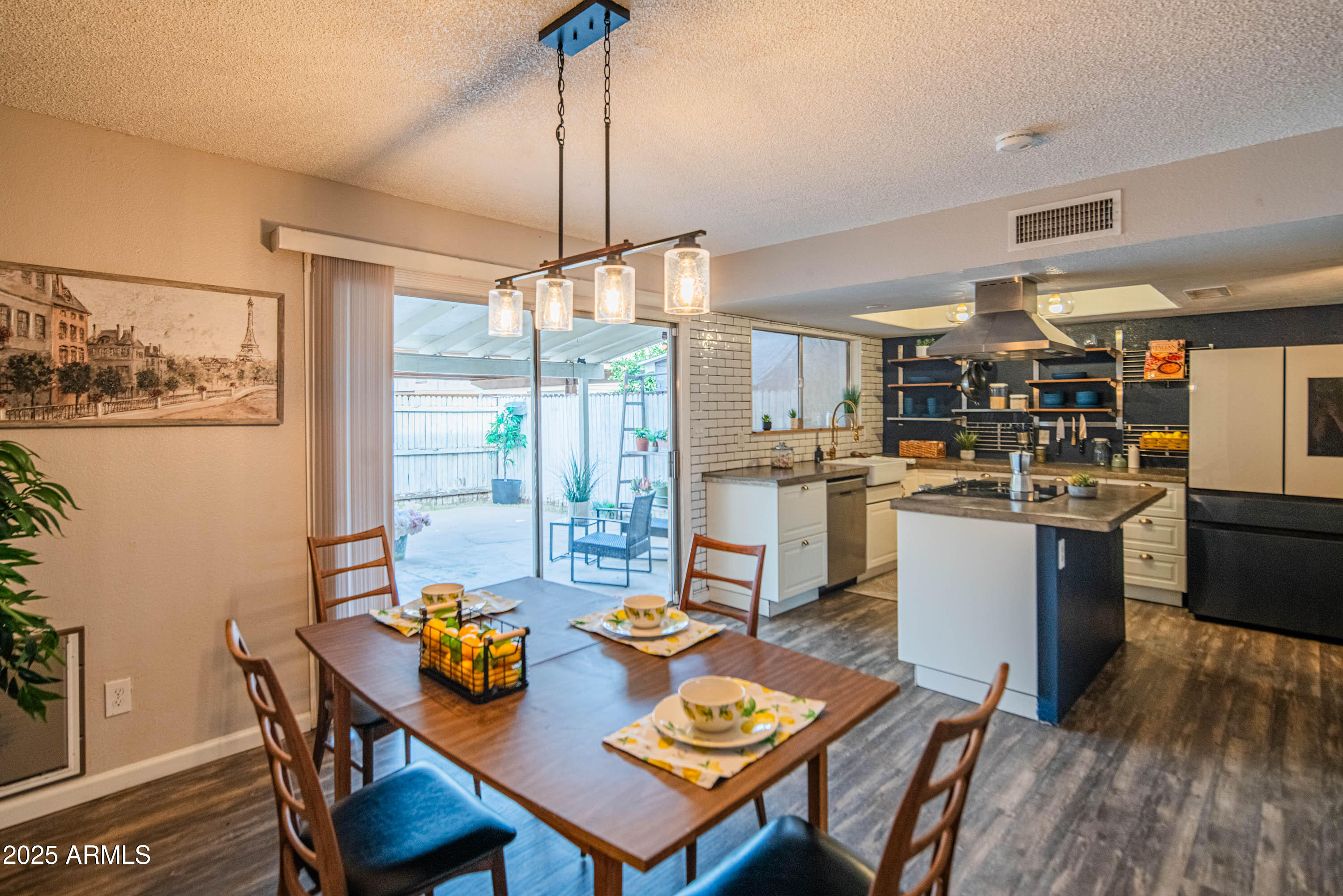 3203 West Royal Palm Road Phoenix, AZ 85051 - Photo 6 of 29 a open dining room with stainless steel appliances kitchen island granite countertop furniture and a wooden floor