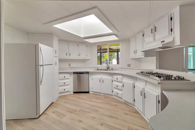 a kitchen with stainless steel appliances a refrigerator sink and cabinets