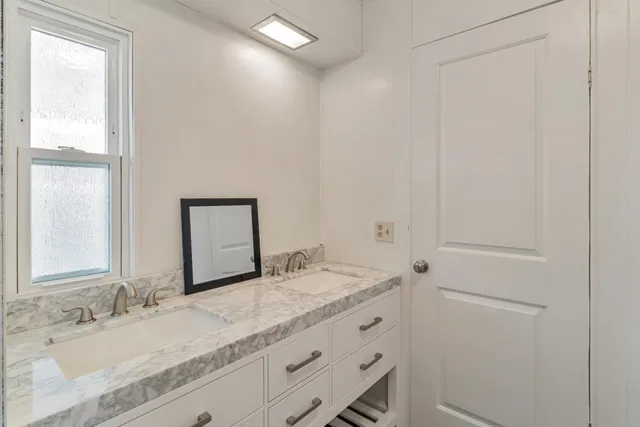 a bathroom with a granite countertop sink and a mirror