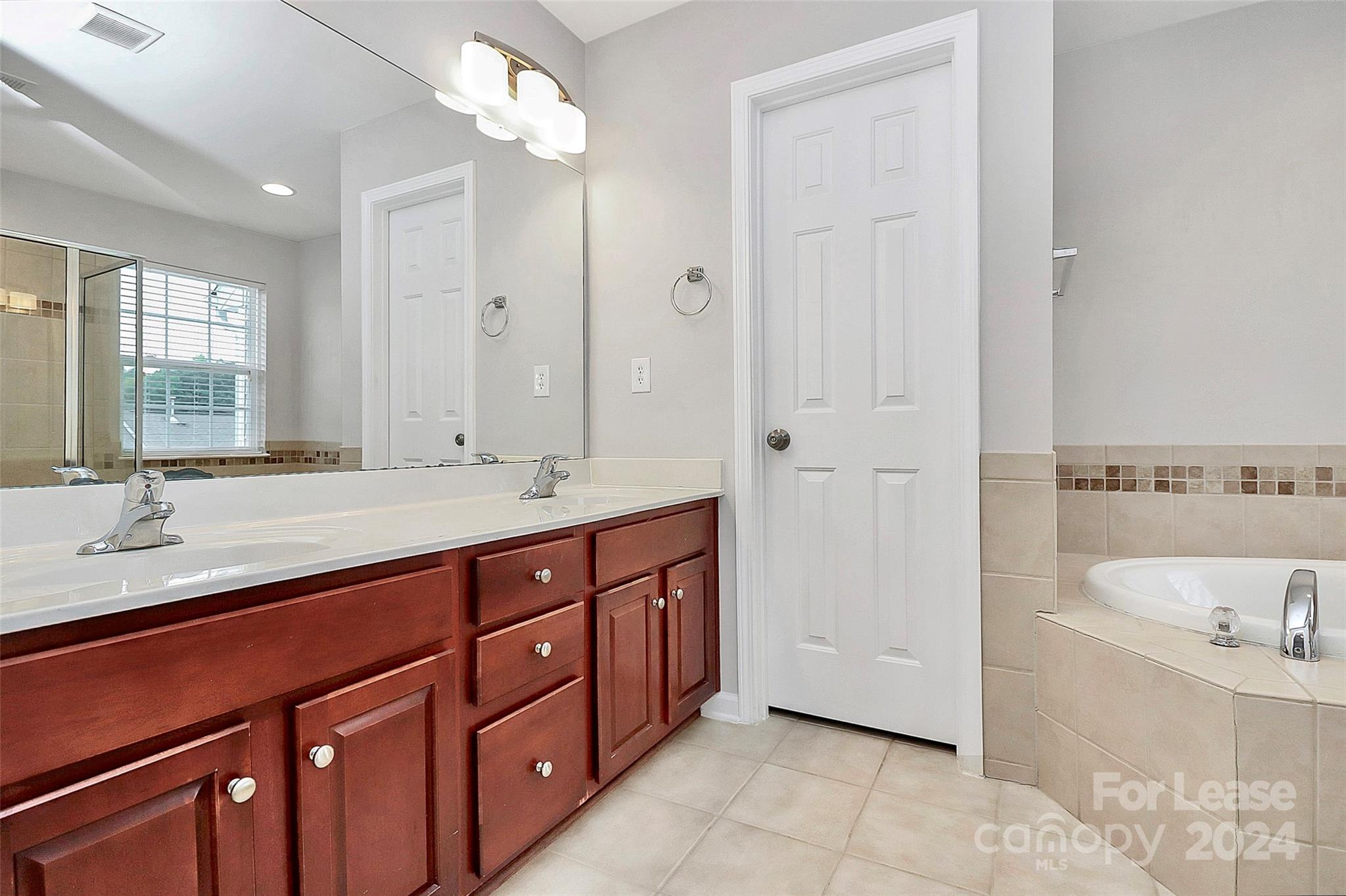 20543 Harbor View Drive Cornelius, NC 28031 - Photo 17 of 35 a spacious bathroom with a tub double sink and mirror