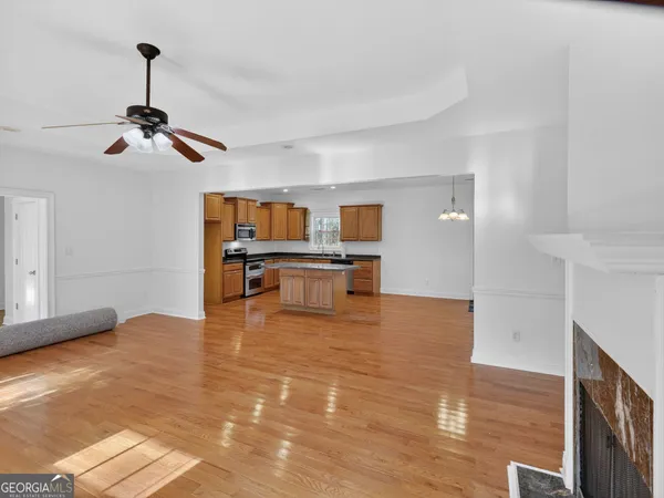 a living room with fireplace furniture and a ceiling fan