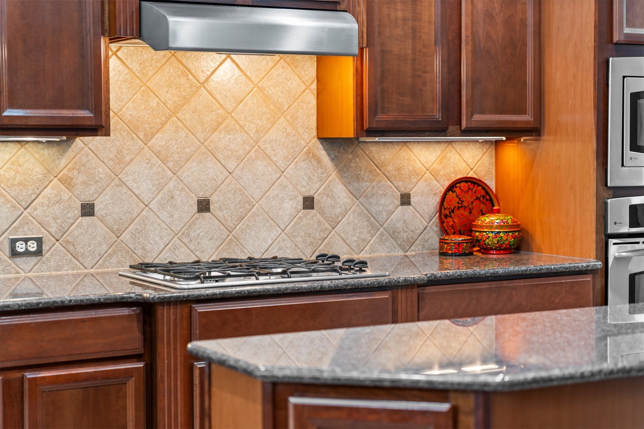 9822 Prairie Clover Lane Spring, TX 77379 - Photo 19 of 46 a kitchen with granite countertop wood cabinets and a stove top oven