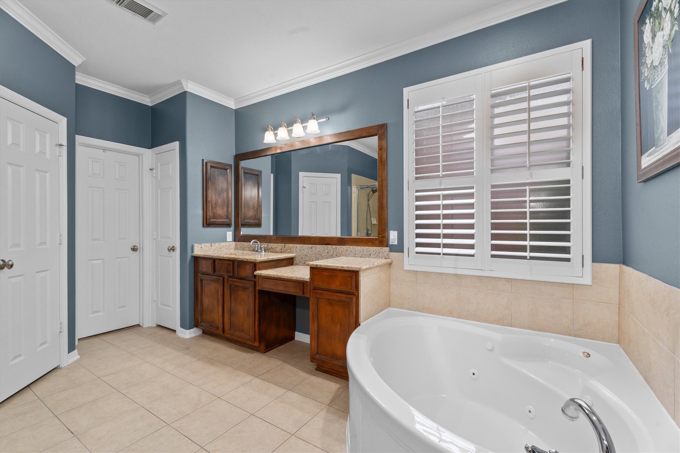 9822 Prairie Clover Lane Spring, TX 77379 - Photo 23 of 46 a bathroom with a tub a sink and a large mirror