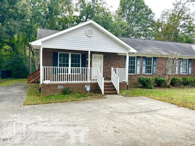 a view of a house with a yard and fence