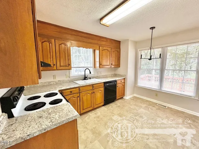 a kitchen that has a sink stove and cabinets