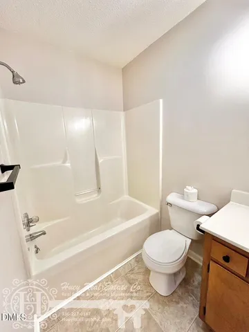 a white toilet sitting next to a bath tub
