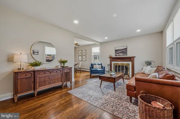 a living room with furniture a fireplace a rug and a window
