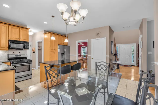 a view of a dining room with furniture a kitchen and chandelier