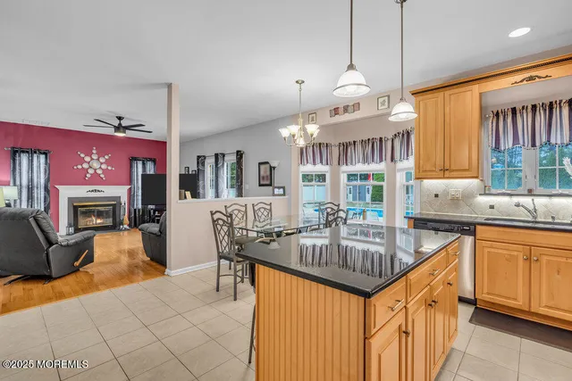 a kitchen with granite countertop a stove a sink dishwasher and a dining table with the kitchen view