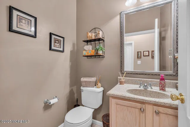 a bathroom with a granite countertop sink mirror vanity and toilet