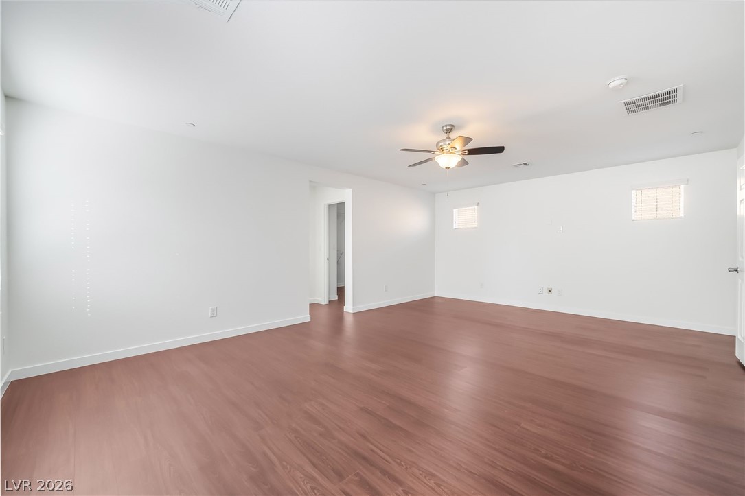 3052 Camino Rico Avenue Henderson, NV 89044 - Photo 22 of 39 Unfurnished room featuring dark wood-type flooring, a ceiling fan, and plenty of natural light