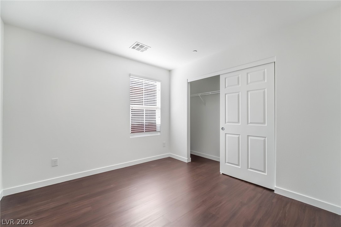 3052 Camino Rico Avenue Henderson, NV 89044 - Photo 27 of 39 Unfurnished bedroom featuring dark wood-style flooring and a closet
