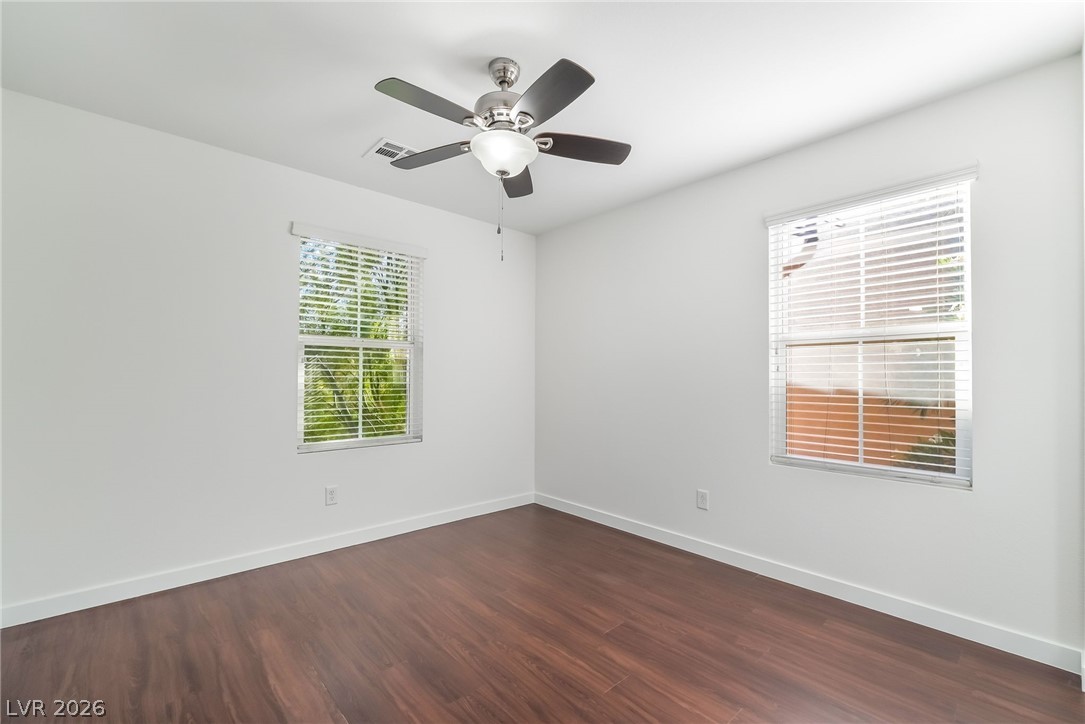 3052 Camino Rico Avenue Henderson, NV 89044 - Photo 32 of 39 Empty room with dark wood finished floors and ceiling fan